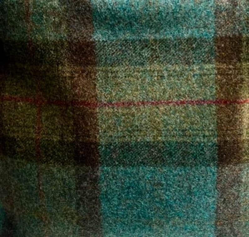 May include: A textured fabric featuring a plaid pattern in shades of teal, olive green, and dark brown. The weave displays a visible, slightly fuzzy surface with thin, horizontal and vertical red lines intersecting across the checkered design.