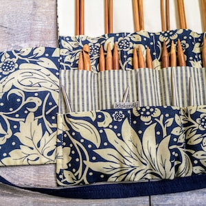 May include: A blue and gold fabric roll-up case with a black strap. The case has multiple pockets for storing knitting needles. The label on the case reads "Wakari Aki".