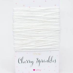 May include: White cotton twine on a card with pink polka dots. The card has the text "shop Cherry Sprinkles etsy" printed on it.