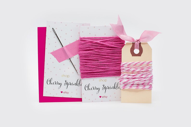 May include: A crafting set featuring pink thread, a needle, and a tag with pink and white twine. The set includes a pink card and two cards with the text "Cherry Sprinkle" and the Etsy logo.