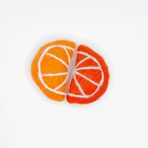 May include: Two felt orange slices, one orange and one red, with white felt lines for the segments. The slices are joined together.