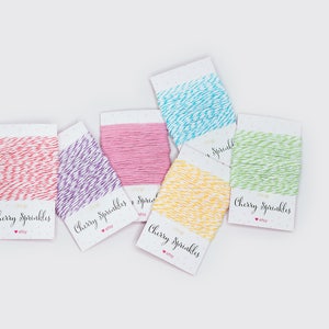 May include: Six spools of colorful baker's twine with the text "Cherry Sprinkles" on each label. The twine colors are pink, purple, blue, yellow, green, and red.