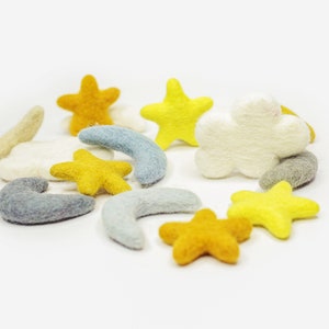 May include: A collection of felt shapes in various colors, including yellow, white, and gray. The shapes include stars, clouds, and crescent moons.