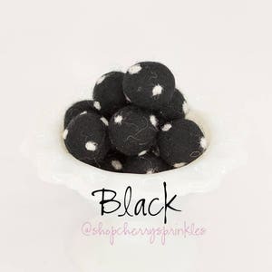 May include: A bowl of black felt balls with white polka dots. The text "Black" and "@shopcherryzsprinkles" is below the bowl.