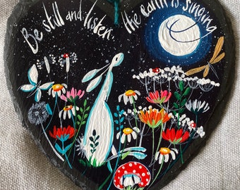 Hand painted on slate heart. A hare & the moon surrounded by flowers ‘ Be still and listen, the earth is singing'. Medium sized  18cm heart