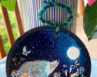 Hedgehog in colourful flower meadow with butterfly and full moon. Hand painted on 11cm round hanging slate.  Celebrating British wildlife.