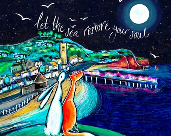 Könnte beinhalten: Eine farbenfrohe Illustration eines weißen Hasen und eines orangefarbenen Fuchses, die nachts unter einem Vollmond gemeinsam auf eine Küstenstadt blicken. Der Text "let the sea restore your soul" steht in weißer Schreibschrift am Sternenhimmel.