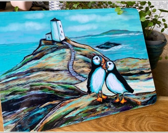 Table mat with a pair of puffins on a rock in front of a lighthouse. Matching products available Melamine with cork backing. UK made