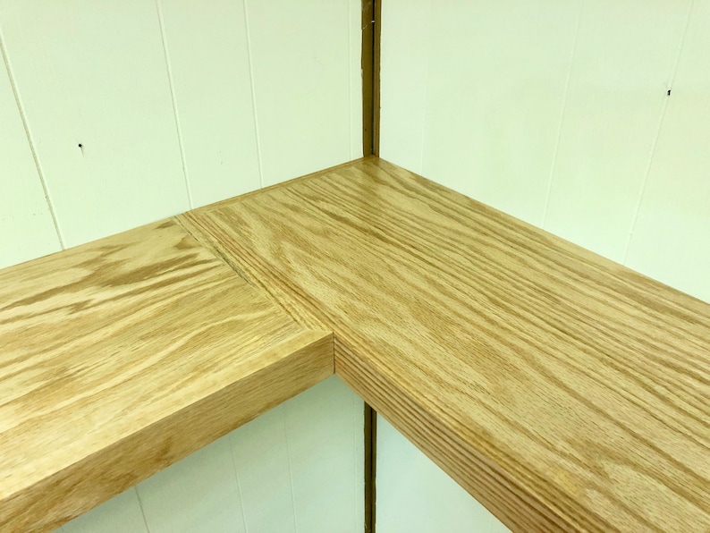 Puede incluir: Dos estantes de madera, uno en esquina y otro recto, est&aacute;n montados en una pared blanca. Los estantes son de madera marr&oacute;n claro con un patr&oacute;n de veta visible.