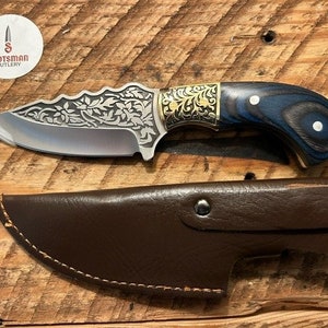 May include: A small, silver knife with a blue and black wooden handle. The knife has a floral design etched into the blade and a leather sheath.