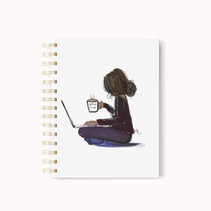 May include: Spiral-bound notebook with a whimsical illustration. The artwork depicts a person sitting cross-legged, using a laptop, and holding a coffee mug. The mug reads "Coffee First". The notebook has a white cover and gold spiral binding.
