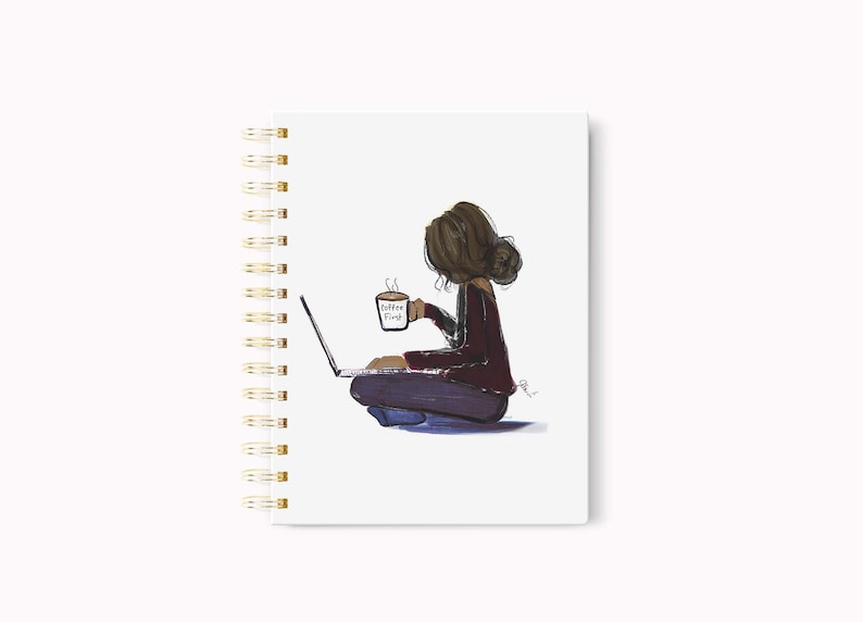 May include: Spiral-bound notebook with a whimsical illustration. The artwork depicts a person sitting cross-legged, using a laptop, and holding a coffee mug. The mug reads "Coffee First". The notebook has a white cover and gold spiral binding.