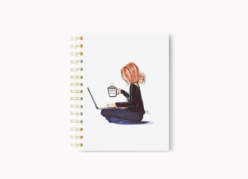 May include: Spiral-bound notebook with a watercolor illustration of a person sitting cross-legged, working on a laptop, and holding a coffee cup. The cup reads "Coffee First". The notebook has a white cover and gold spiral binding.