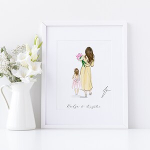 May include: A framed art print featuring a watercolor illustration of a woman and a child walking away, the woman holding pink flowers. The print is in a white frame, with the names "Raelyn & Krystee" below the image.