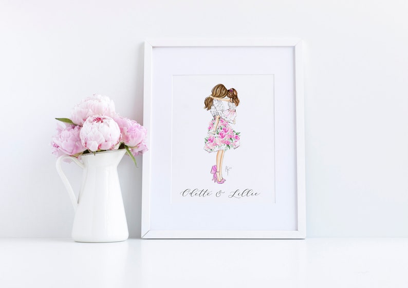 K&ouml;nnte beinhalten: Ein wei&szlig;er Rahmen mit einer Aquarell-Illustration von zwei Frauen in pinken Blumenkleidern, die sich umarmen. Der Text "Chelle & Lillie" steht unter der Illustration.