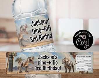 May include: Water bottle label with a dinosaur theme. The label features a green and brown dinosaur with a blue sky and palm trees in the background. The text on the label reads "Jackson's Dino-Rific 3rd Birthday!"