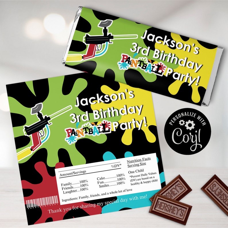 May include: A green, black, yellow, and red personalised chocolate bar wrapper with a paintball gun design. The wrapper says "Jackson's 3rd Birthday Paintball Party!" and "Personalize with Cory!"