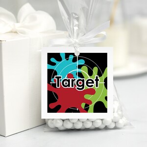 May include: A black and white favour tag with a target design and colourful paint splatters. The tag says "Target" in bold black letters.