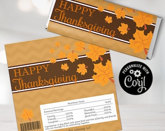 以下が含まれることがあります： 茶色と黄褐色のシェブロン柄、オレンジ色のカエデの葉、Happy Thanksgivingの文字がデザインされた長方形のチョコレートバー用包装紙と正方形のラベル。ラベルには、お祝いの言葉が書かれた栄養成分表示パネルが含まれています。