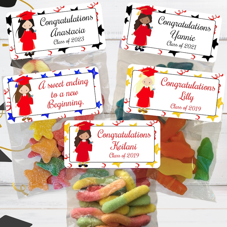 May include: Four graduation gift bags with colorful candy and personalized labels. The labels feature a cartoon girl wearing a graduation cap and gown. The labels include the names Anastacia, Yannie, Lilly, and Keilani, along with their graduation year.