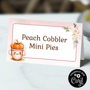 Könnte beinhalten: Rosa-weißes, bedruckbares Lebensmitteletikett mit dem Text "Peach Cobbler Mini Pies" und einem niedlichen Cartoon-Kürbis in einer Tasse. Das Etikett hat ein florales Design in der Ecke.