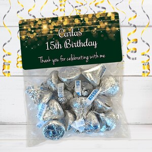 Puede incluir: Una bolsa de regalo verde y dorada con una etiqueta personalizada que dice "Carla's 15th Birthday. Thank you for celebrating with me." La bolsa est&aacute; llena de besos de chocolate envueltos en papel plateado.