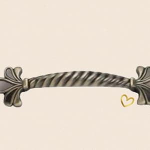 May include: A silver-toned cabinet pull with a twisted design and decorative fleur-de-lis ends.