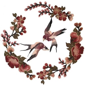 Puede incluir: Parche de aplique bordado con dos pájaros rosas volando entre ramas florales rosas y marrones.