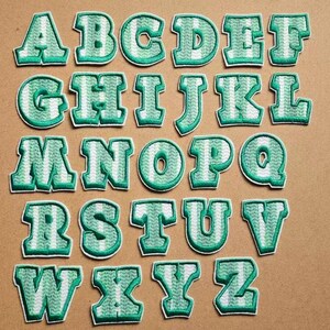 Parche adhesivo verde con letras bordadas, perfecto para pegar en la mochila, el portátil o el libro.