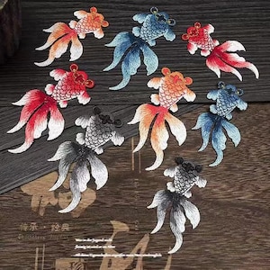 May include: Assortment of embroidered iron-on patches featuring colorful goldfish designs. The patches are perfect for adding a touch of whimsy to clothing, bags, or other fabric items.