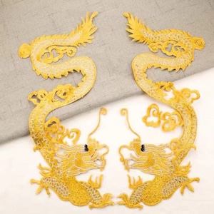 May include: Two gold embroidered iron-on patches of dragons. The dragons are facing opposite directions and have intricate details.