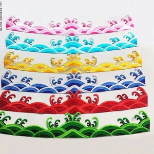 May include: Six embroidered fabric trims with a wave design. The trims are in pink, blue, yellow, blue, red, and green.