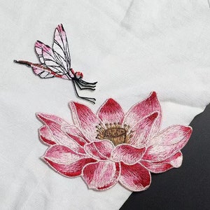 Op de afbeelding: Twee geborduurde strijk-op patches, een roze libellen en een roze lotusbloem.