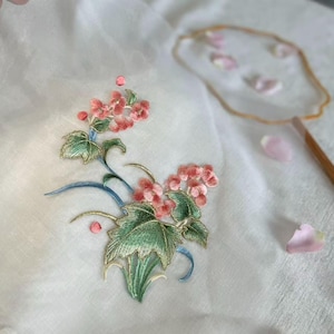 刺繍の花のアップリケと白いネットパッチ付きセーターまたはコートの装飾パッチ。縫い付けパッチ。