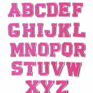 Puede incluir: Un conjunto de letras del alfabeto bordadas en rosa, difusas, cada una con un contorno blanco. Las letras están dispuestas en filas, mostrando todo el alfabeto de la A a la Z. Las letras son de estilo bloque en negrita.