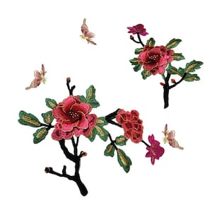 May include: Embroidered iron-on patches featuring pink flowers with green leaves and gold accents. There are three butterflies in the design, all with pink and gold accents.