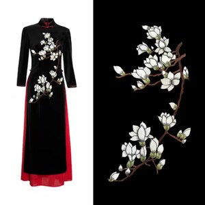 May include: A black velvet dress with a red underskirt and white embroidered magnolia flowers.