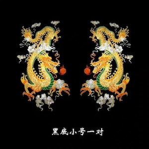 Könnte beinhalten: Zwei goldene Drachen, die sich auf einem schwarzen Hintergrund gegenüberstehen. Jeder Drache hält eine rote Kugel im Maul. Die Drachen sind von Wolken umgeben und der Text "黑底小, 弓一对" ist darunter geschrieben.