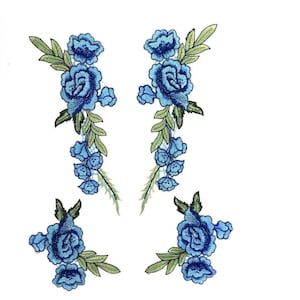 Op de afbeelding: Vier blauwe geborduurde bloemenapplicaties met groene bladeren. De applicaties bevatten een grote roos met kleinere bloemen en bladeren.