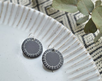 Black and white round drop earrings with white geometric pattern, handmade ceramic jewelry