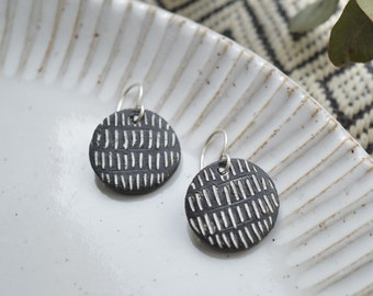 Round black dangle earrings with white geometric pattern, handmade ceramic jewelry