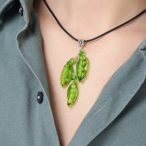 May include: A green glass pendant necklace with a black cord.