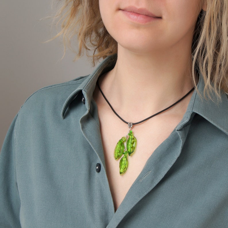 May include: A green glass pendant necklace with a black cord.