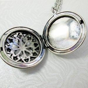 inside view of opened locket which shows compartment place to hold small things or photo or perfume pad.