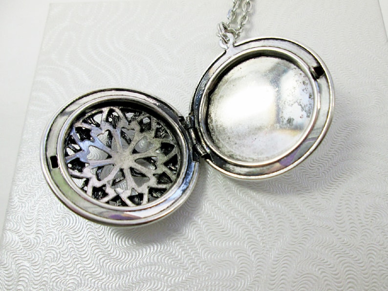 inside view of opened locket which shows compartment place to hold small things or photo or perfume pad.