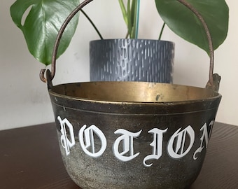 Letras pintadas a mano en una olla de caldero fundido antigua