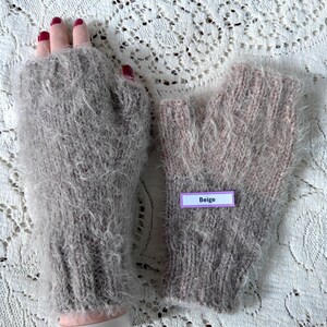 May include: A pair of beige fingerless gloves made of a soft, fuzzy material. The gloves are a light beige color with a label that reads "Beige". The gloves are designed to keep hands warm while leaving fingers free.
