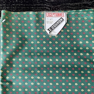 Op de afbeelding: Groene stof met een klein wit en rood bloemenpatroon. De stof heeft een label met de tekst "Exceptionnel" en "Le Coupon".