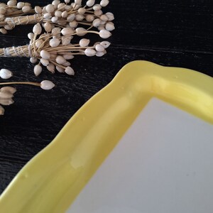 以下が含まれることがあります： 白い内側と波状の縁を持つ黄色いセラミック製のサービングディッシュ