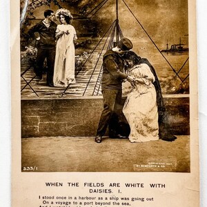 Peut inclure: Carte postale vintage sépia représentant deux couples, l'un en uniforme de marin, l'autre en civil. Un couple s'embrasse sur une jetée, tandis que l'autre se tient à proximité. La carte comprend le texte d'un poème.